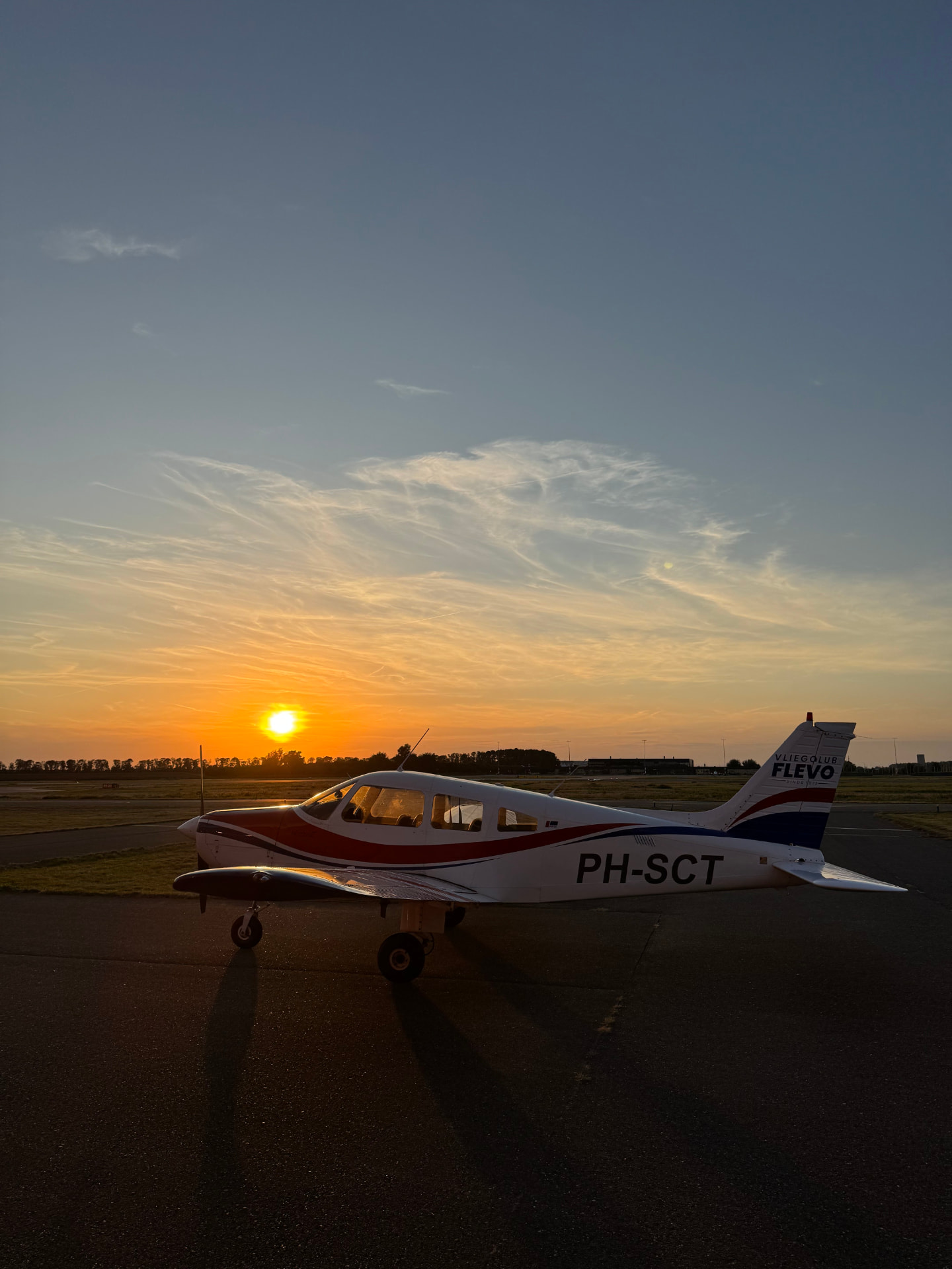 De Piper PA-28 Warrior PH-SCT op het platform van Lelystad Airport bij zonsondergang