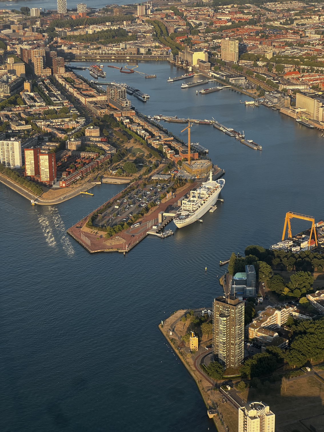 De ss Rotterdam aan de Katendrechtse kade in het gouden avondlicht, gezien vanuit het vliegtuig