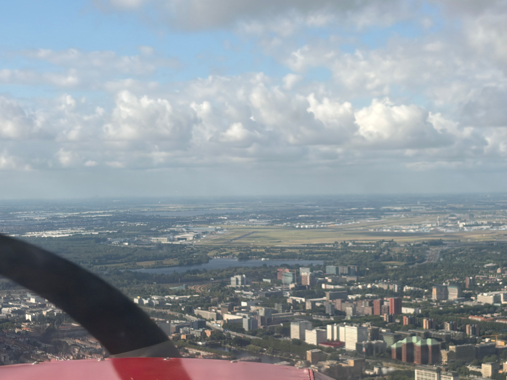 Amsterdam-Zuid en de Zuidas met op de achtergrond de banen van Schiphol, gezien vanuit een klein vliegtuig