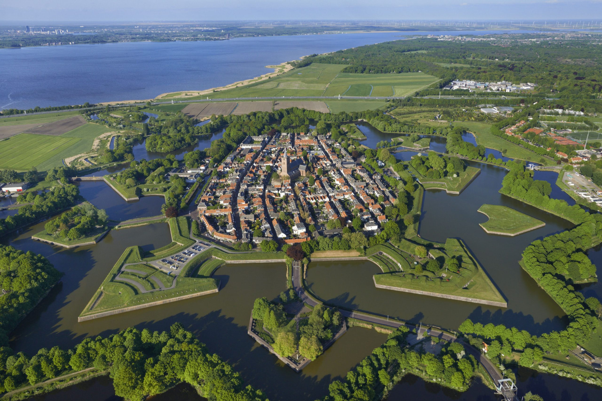 The star-shaped fortress town of Naarden with its moats and bastions from the air over the wing of the Piper PA-28 during a sightseeing flight over the Netherlands