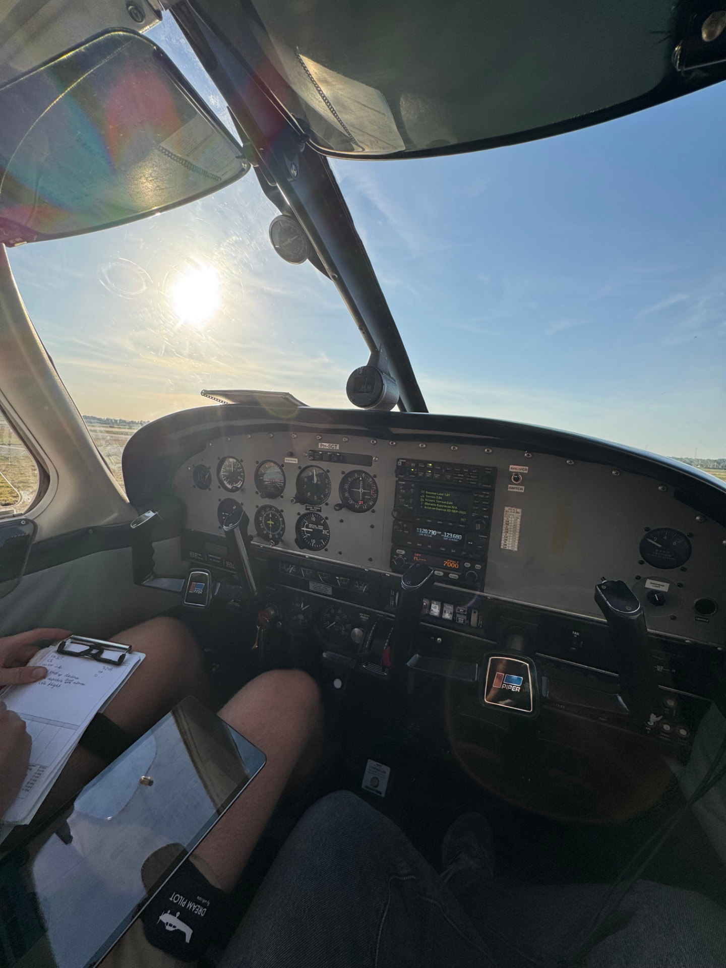 Cockpit van de PH-SCT met instrumentenpaneel en laagstaande zon boven Lelystad