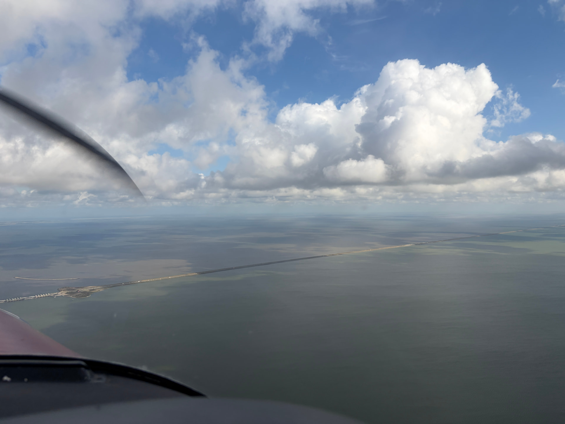 De kaarsrechte Afsluitdijk tussen IJsselmeer en Waddenzee, gezien vanuit de cockpit